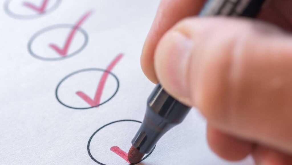 Someone using a marker to check off tasks on a psychiatric service dog task list.